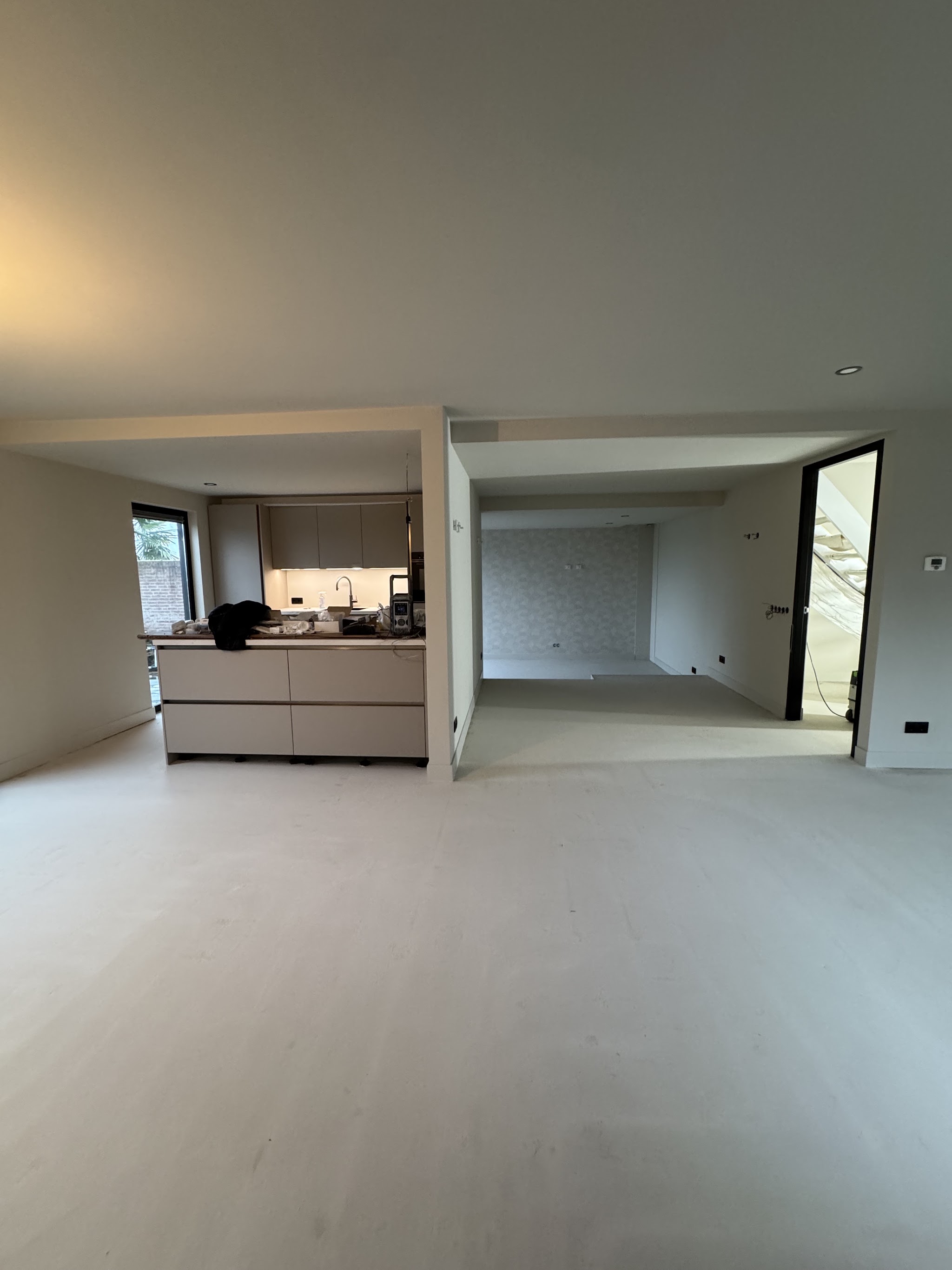 Pas geschilderde woonkamer met open keuken en lichte wanden