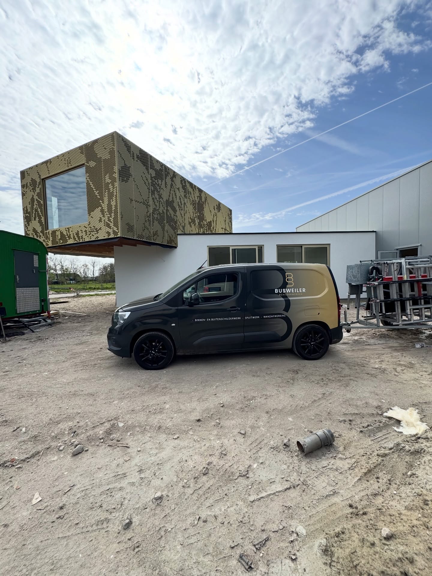 De zwarte bedrijfsbus van Busweiler Schilderwerken op een bouwplaats